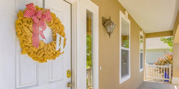Front porch and white door with yellow wreath