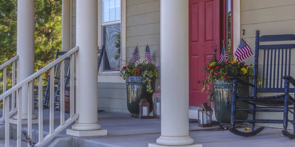 Front porch with stairs red door and rocking chair