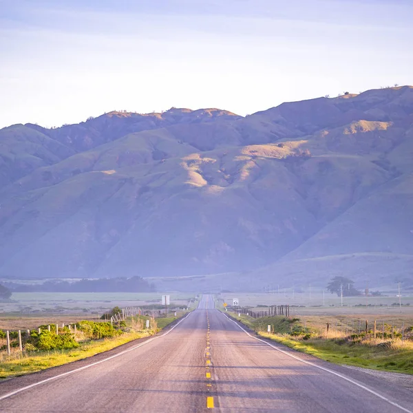 Auto-estrada com vista para uma imensa montanha na CA — Fotografia de Stock