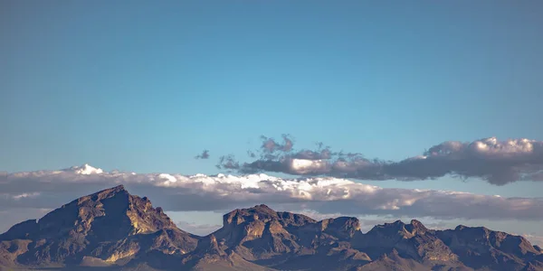 Зазубренная гора под облачным голубым небом — стоковое фото