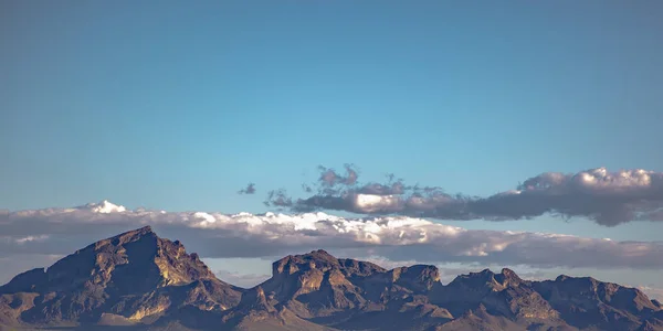 Jagged mountain beneath a cloudy blue sky