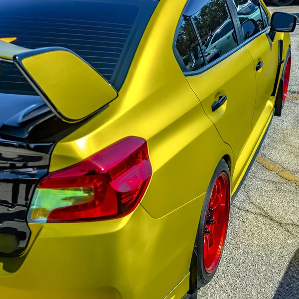 Carro amarelo metálico com aro de roda vermelha brilhante — Fotografia de Stock