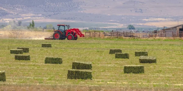 Κόκκινο τρακτέρ και παλιό αχυρώνα σε ένα πεδίο σε Utah Valley — Φωτογραφία Αρχείου