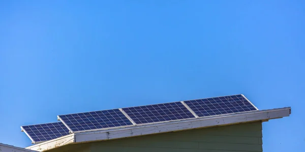Mavi gökyüzü karşı bir çatısında güneş panelleri — Stok fotoğraf