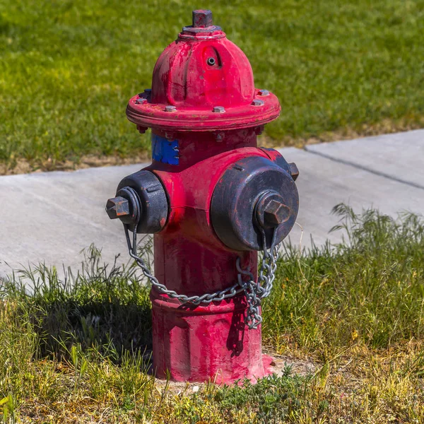 Weathered red fire hydrant on a grassy ground