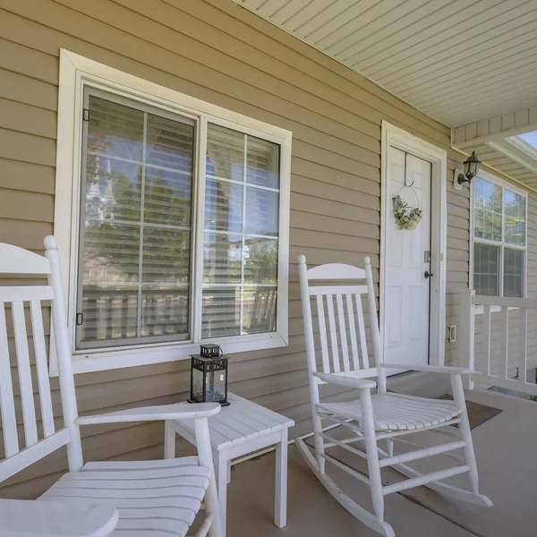 White door and porch with rocking chairs and table