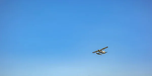 Witte float vliegtuig vliegt onder de blauwe hemel — Stockfoto