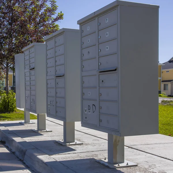 Bílé poštovní schránky s stíny na chodníku — Stock fotografie