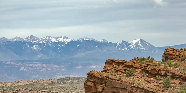 Cliff with snow capped La Sal Mountain in Moab UT — Stock Photo, Image