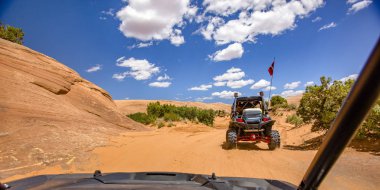 Road'a benziyor içinde Moab bulutlar ile mavi gökyüzünün altında. Görüntülemek bir off road içinde Moab, Utah tozlu bir iz üzerinde seyahat araç. Güneşli bir günde bulutlar ile parlak mavi gökyüzü altında Road'a benziyor sayısı.