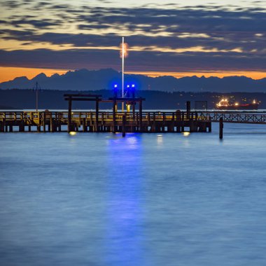Gün batımında, gümüş rengi bir sakin Okyanusu üzerinden Tacoma pier
