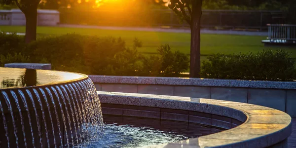 Fuente exterior con agua reflectante al atardecer — Foto de Stock