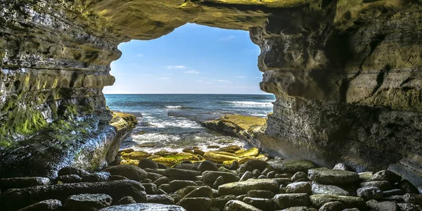 Grotta rocciosa sul mare con vista sull'oceano e sul cielo — Foto Stock