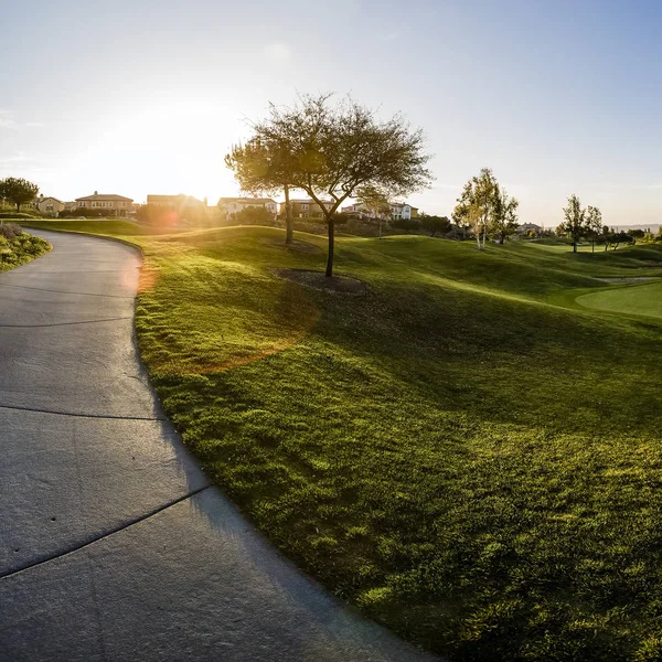 Kaldırım ve golf course yakınındaki binasına günbatımı — Stok fotoğraf
