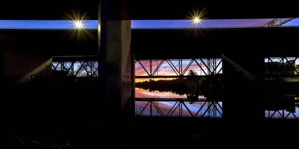 Brücke am Meer mit Himmel, der sich auf dem Wasser spiegelt — Stockfoto