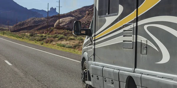 Gray vehicle travelling on a sunny mountain road — Stock Photo, Image