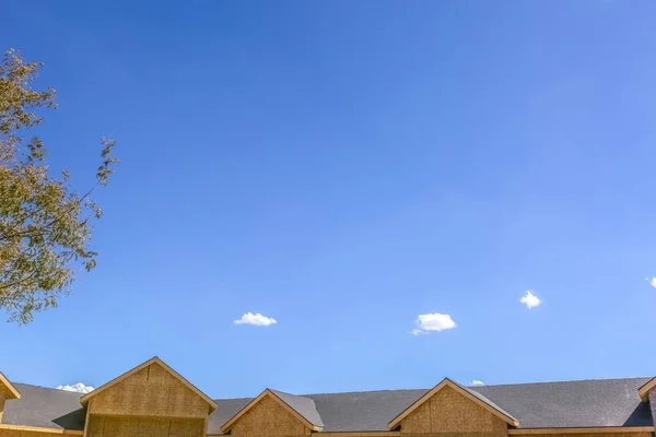 木と家に雲がかかる鮮やかな青い空 — ストック写真