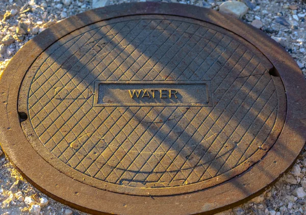 Man gat deksel met label van water op de voorkant — Stockfoto