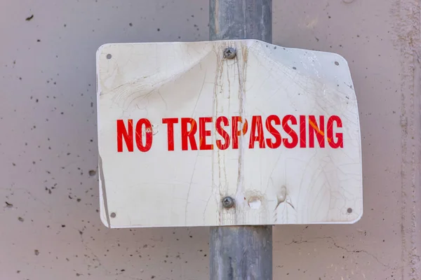 No trespassing sign on a wall close up with pole — Stock Photo, Image