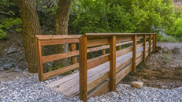 Hiking trail with wood bridge over a rocky stream