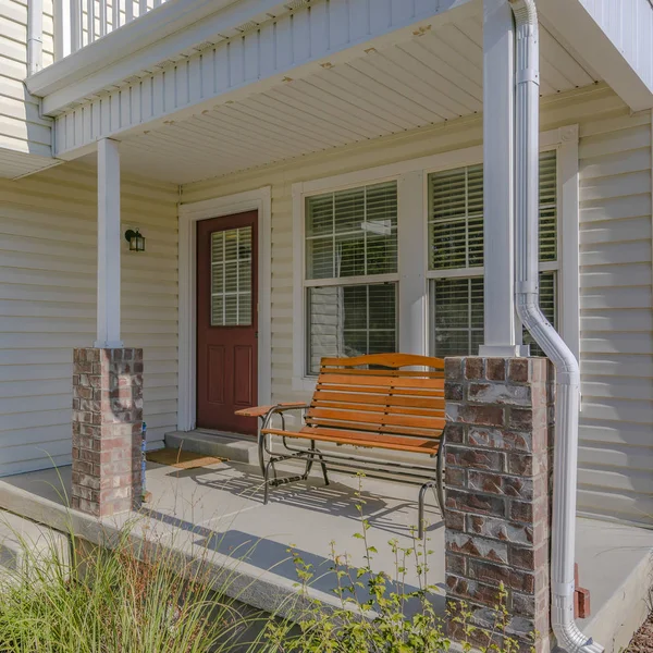 Rumah dengan teras depan yang diterangi sinar matahari dan pintu coklat — Stok Foto