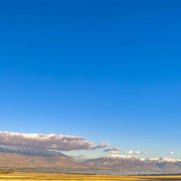 Zářivé nebe nad klidné jezero a zasněžené hory — Stock fotografie