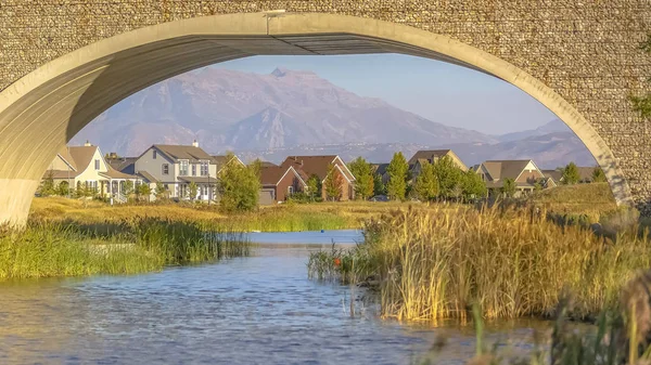 Ponte d'arco con case sul lago e vista sulle montagne — Foto Stock