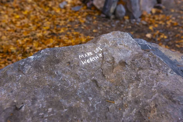 Make life worth it written on a rock seen on hike