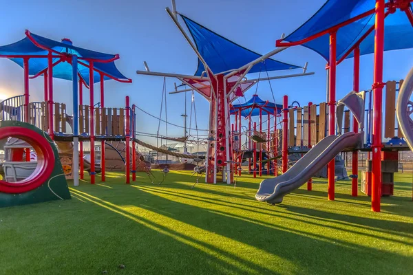 Luz solar lançada no playground cores vermelhas e azuis — Fotografia de Stock