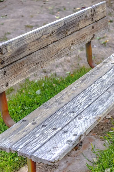 Weathered wooden bench with rusting metal support — Stock Photo, Image