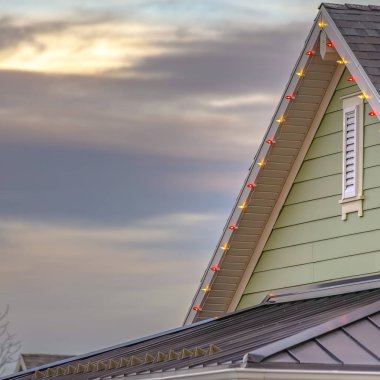 Noel ışıkları Daybreak Utah bir ev çatısı kenarında. Işıkları çeşitli renk ve ev yeşil ve günbatımında gökyüzünün ile görülebilir.