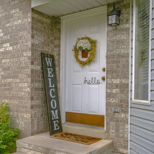 Casa con puerta delantera blanca y letrero de bienvenida — Foto de Stock