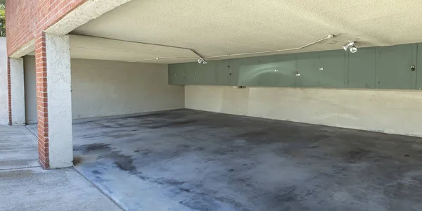 Open garage of a brick building with wall cabinets