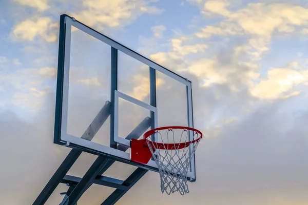 Basketbalový koš a deska proti zatažené obloze — Stock fotografie