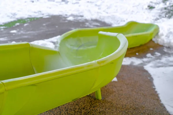 Scivolo verde su un parco giochi innevato nello Utah — Foto Stock