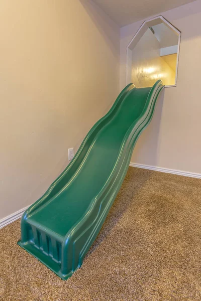 Indoor playset with slide in a white walled room