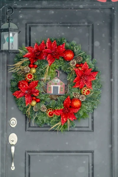Dark front door with red and gold Christmas wreath