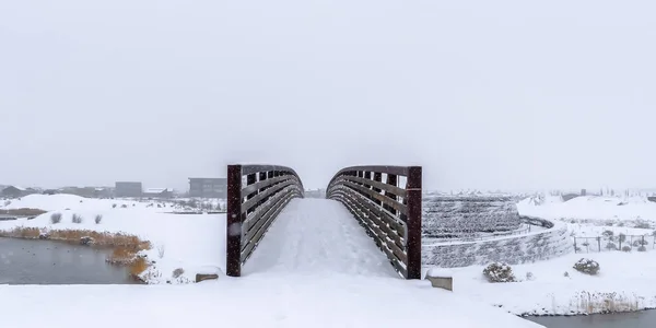 Puente sobre el lago contra una manta de nieve en Utah — Foto de Stock