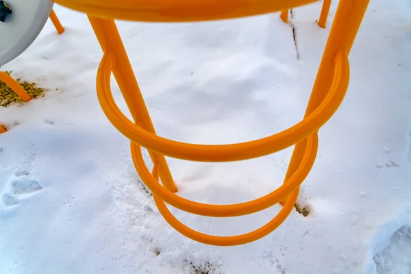 Bright orange ladder against powdery shite snow