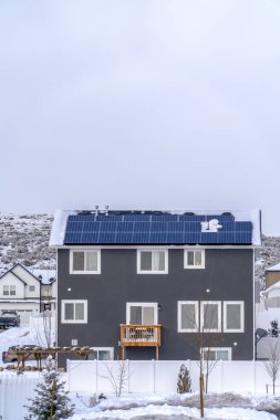 Eagle Mountain, Utah çatısında güneş panelleri ile kartal dağ UT evinde çatıya güneş paneli ile ev. Doğal kış manzarası ile zemin ve toz karla kaplı ağaçlar.