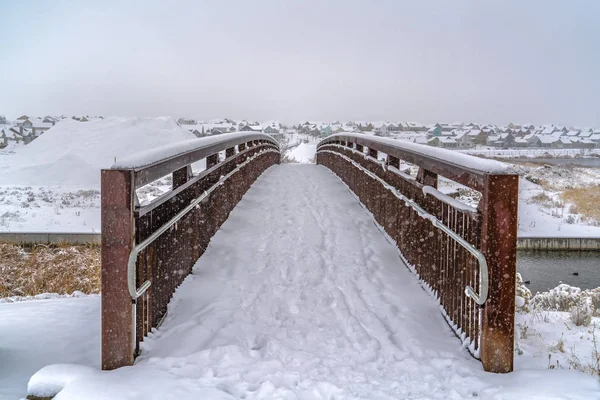 Un puente con vistas a un lago cubierto de nieve — Foto de Stock