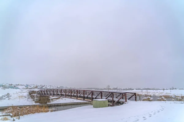 Ponte sobre o lago contra uma paisagem de inverno gelada — Fotografia de Stock