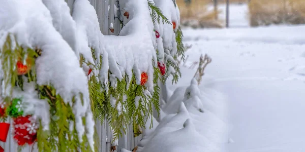 Guirlanda de Natal envolta em uma cerca no inverno — Fotografia de Stock