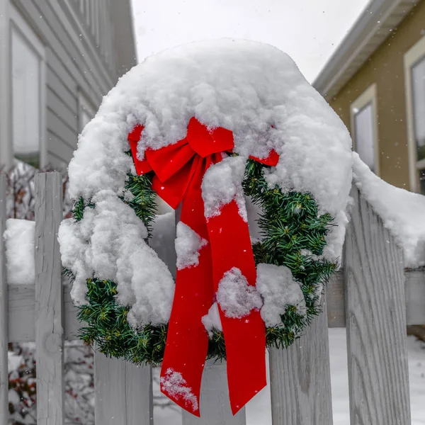 Snow covered wreath on white picket fence in Utah — Stock Photo, Image