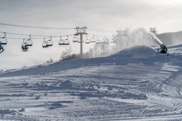 Snow gun and ski lifts on a sunny winter in Utah