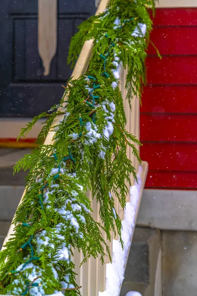 Handrail with snowy garland and Christmas lights