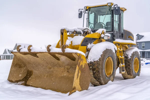 Loader przed śniegiem i domów w Utah brzask — Zdjęcie stockowe