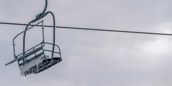 Elevador de esqui com neve e icicles contra o céu brilhante — Fotografia de Stock