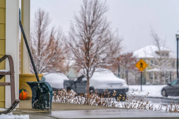 Pala de nieve con calle nevada en el fondo — Foto de Stock