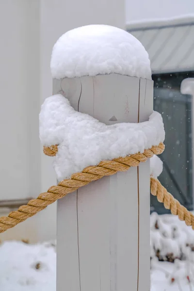 Pólo de madeira com corda coberta de neve no inverno — Fotografia de Stock